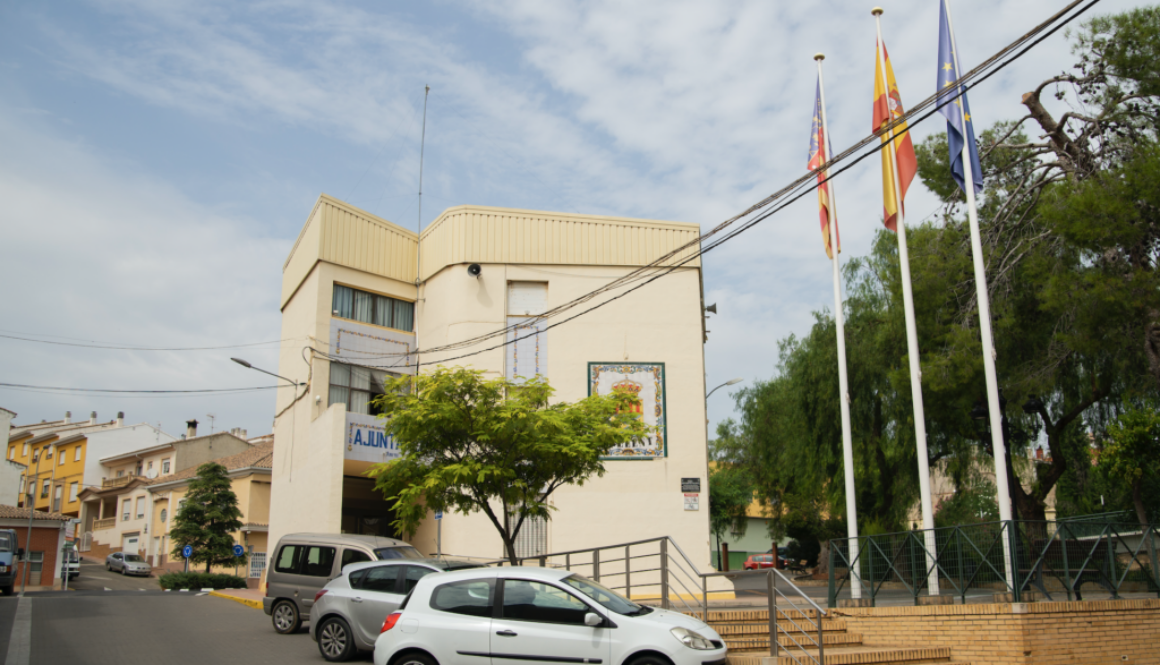 Entrada a l'ajuntament des del carrer amb escales i una rampa amb barana per a persones amb mobilitat reduïda.