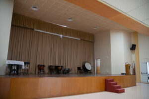 Escenari de la sala d'actes de la Casa de la Cultura amb alguns instruments musicals en repòs.