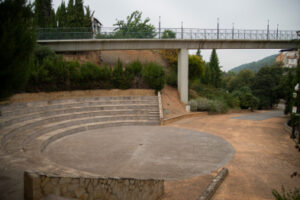 Amfiteatre de pedra i passarel·la aeria situats al Parc Jaume I amb fons d'entorn natural.