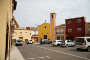 Façana completa de l'església de la Immaculada Concepció i l'entorn urbà amb cotxes aparcats en la plaça.